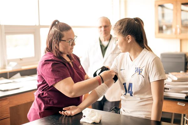 Student working with teacher in a health and medical science class.